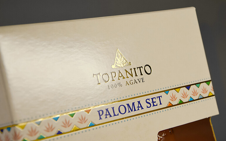 Gold auf cremefarbenem Grund: Das heißfoliengeprägte Topanito-Logo setzt einen Akzent auf der Vorderseite der von Karl Knauer produzierten Präsentverpackung. Das grafische Design stammt von Perola. © Karl Knauer KG