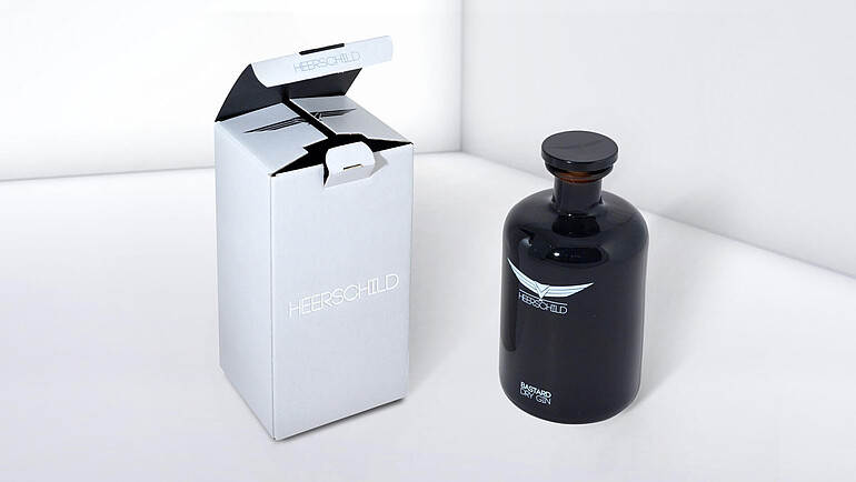 Schwarze Ginflasche mit weißer Verpackung