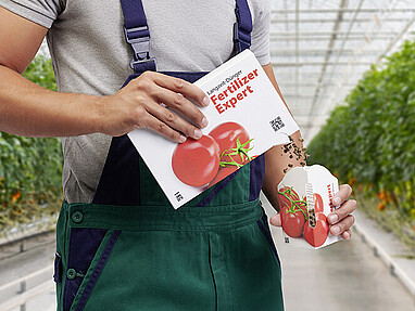 Produkt wird durch Verpackungsöffnung in Messbecher geschüttet