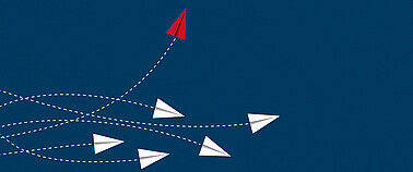 Papierflieger auf blauem Hintergrund